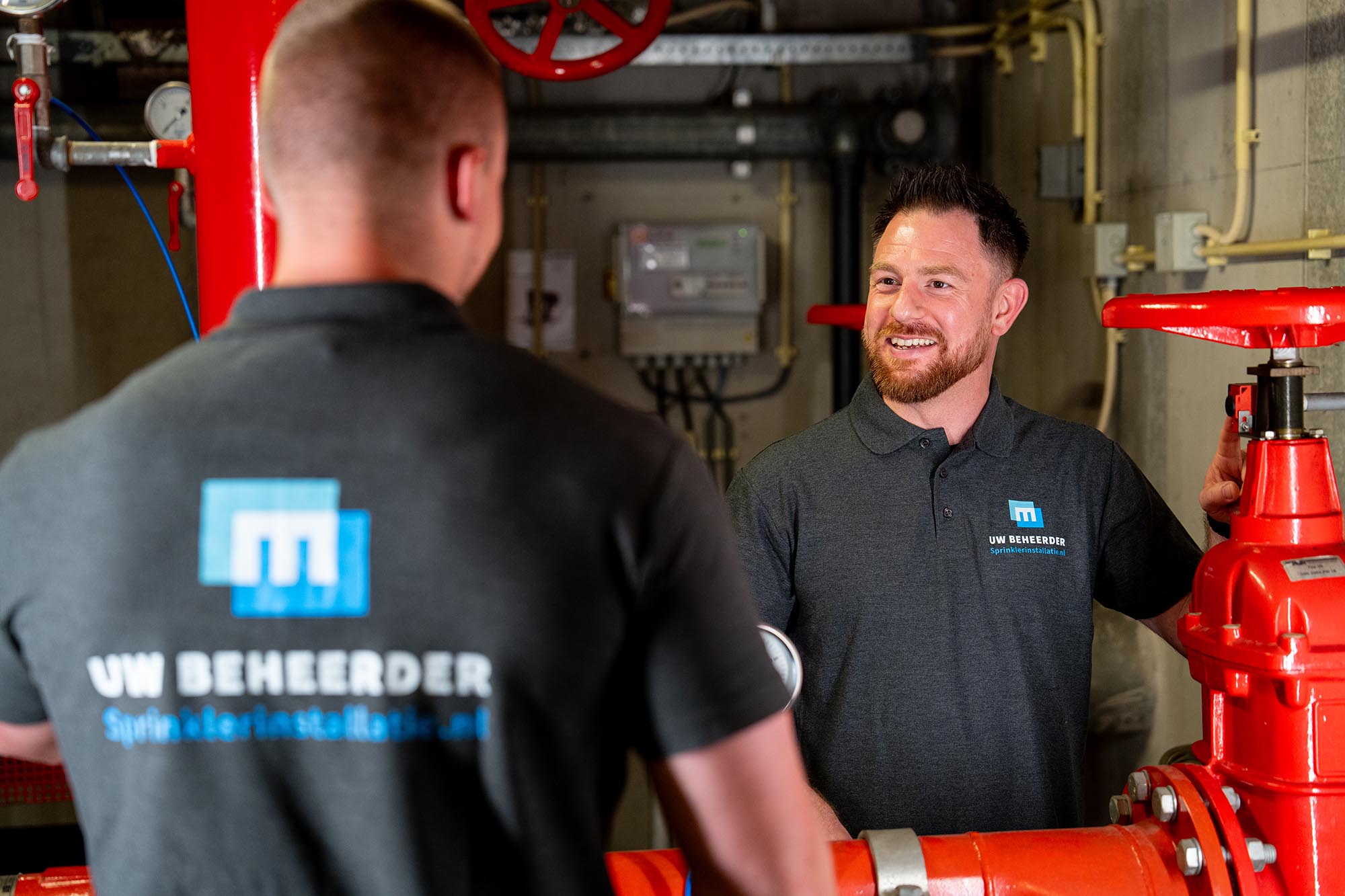 Collega's aan het werk met nieuwe polo's. Uwbeheerdersprinklerinstallaties